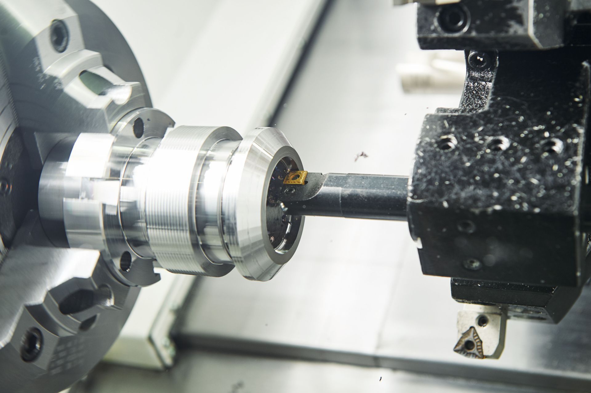 A CNC lathe machining a metal part; cutting tool removing material.