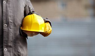 a worker holding a yellow hard hat