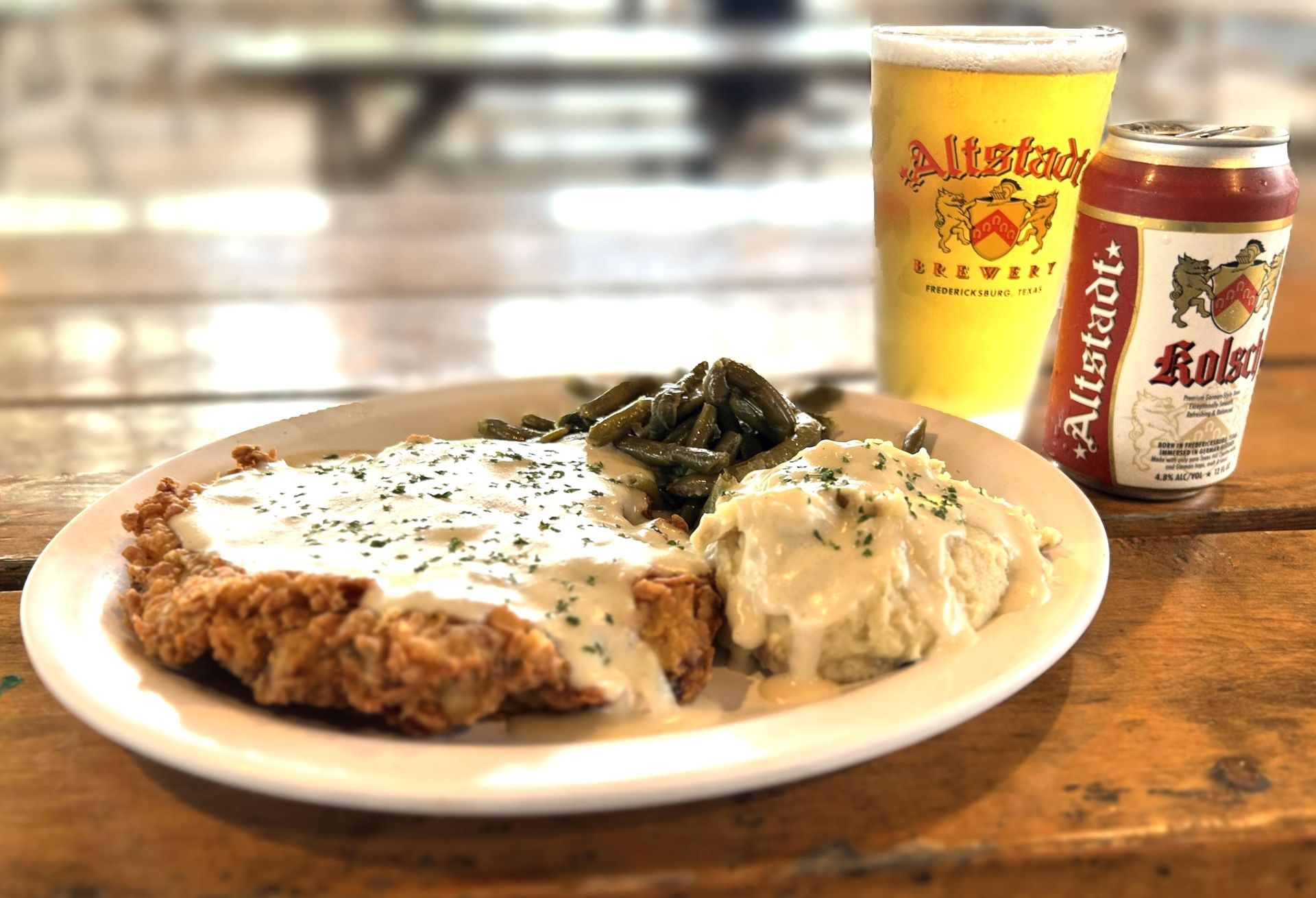 A plate of food and a can of beer on a table.