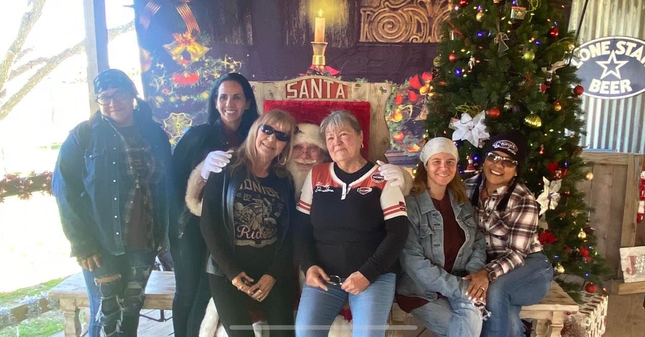 A group of people are posing for a picture with Santa Claus.