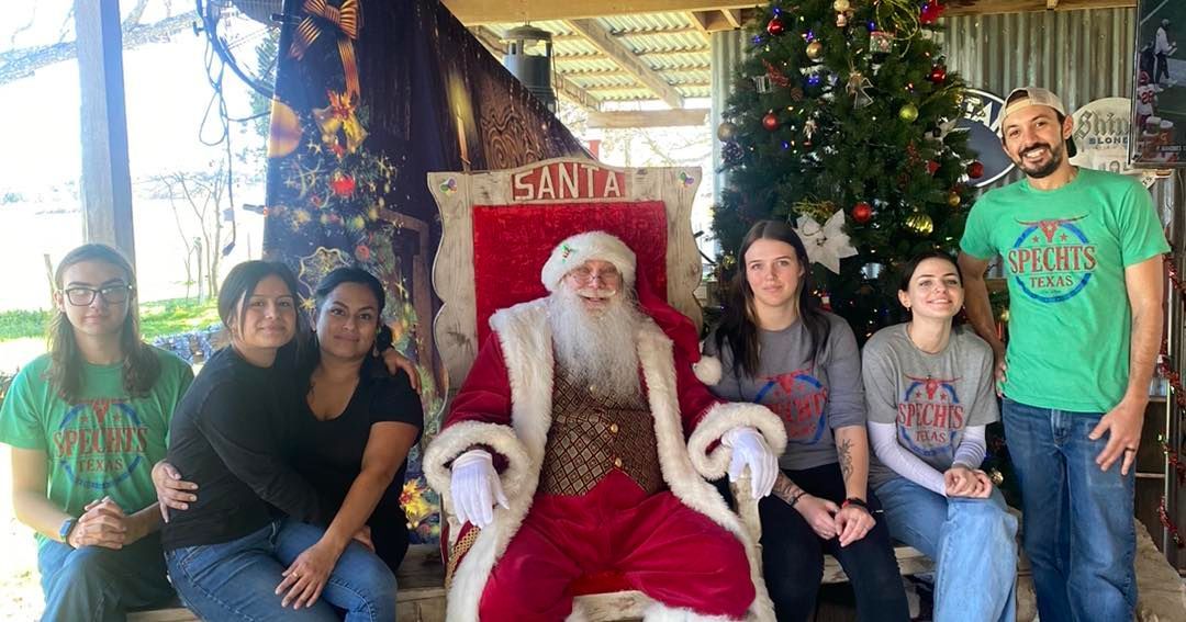 A group of people are posing for a picture with Santa Claus.