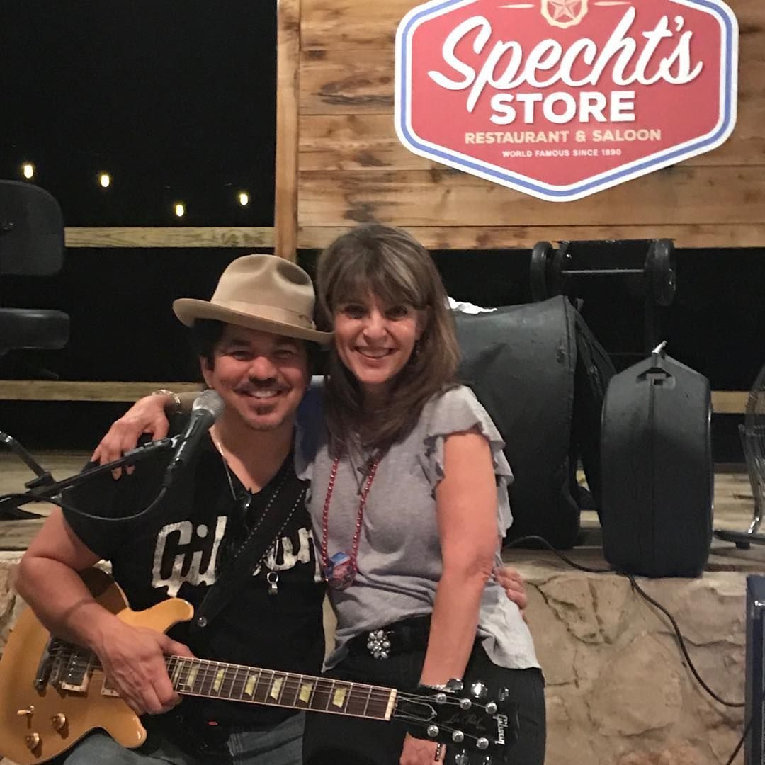 A man and woman are posing for a picture in front of a speech store sign.