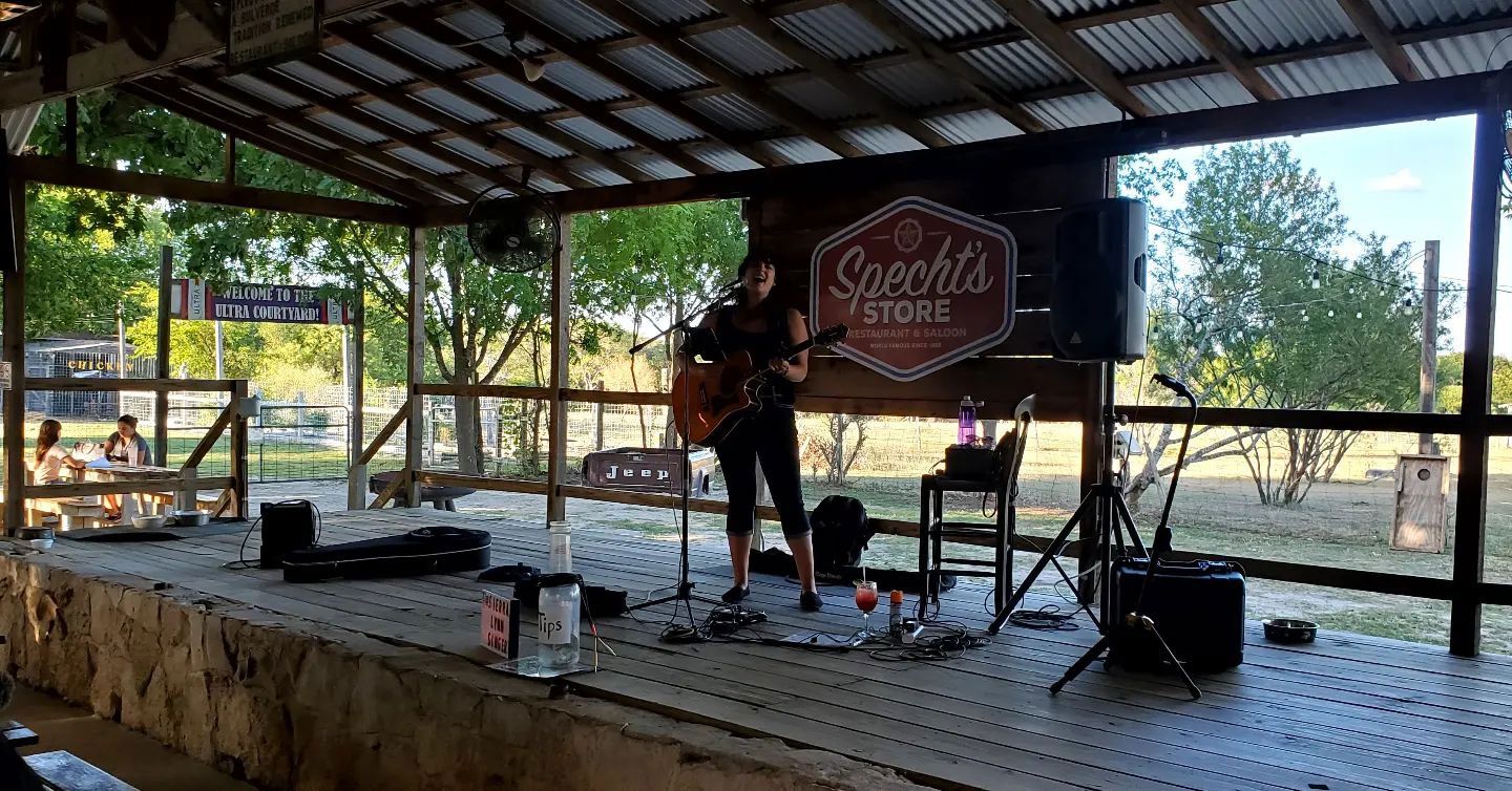 A white plate topped with a slice of pizza and avocado.