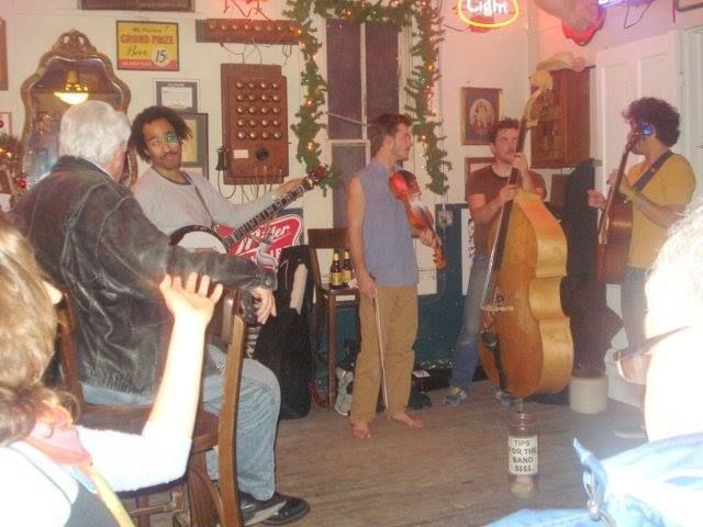 A group of people playing instruments in front of a sign that says Bud Light.