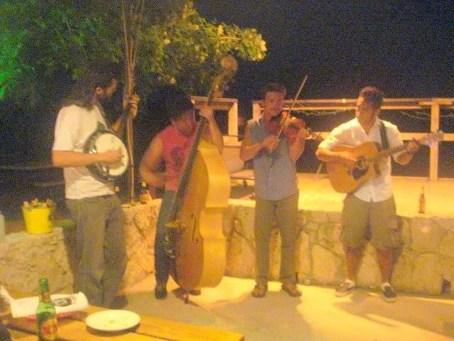A group of men are playing musical instruments outside at night.