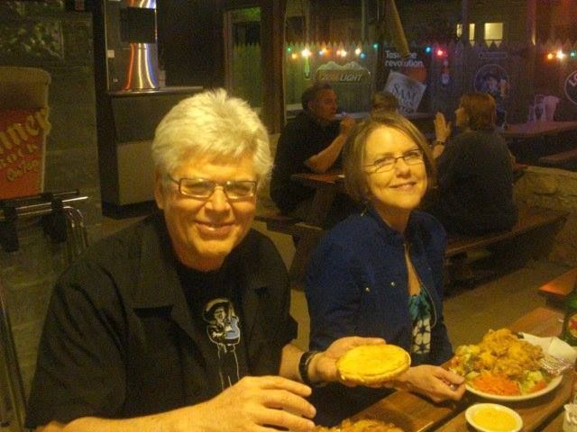 A man and a woman are sitting at a table eating food.
