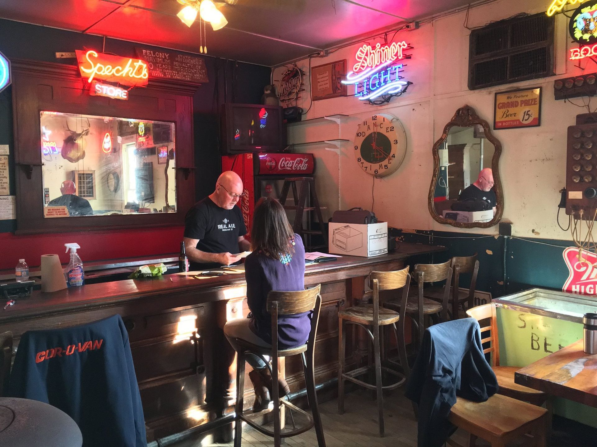 A man and a woman are sitting at a bar in a restaurant.