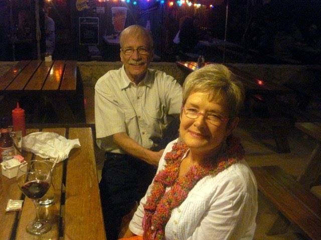 A man and a woman are sitting at a picnic table.