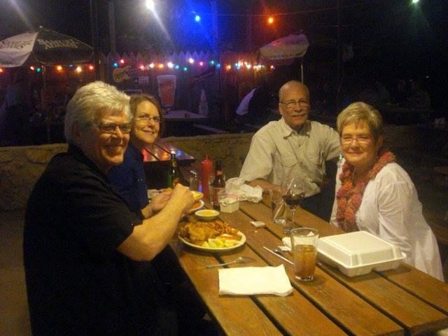 A group of people are sitting at a table with food and drinks.