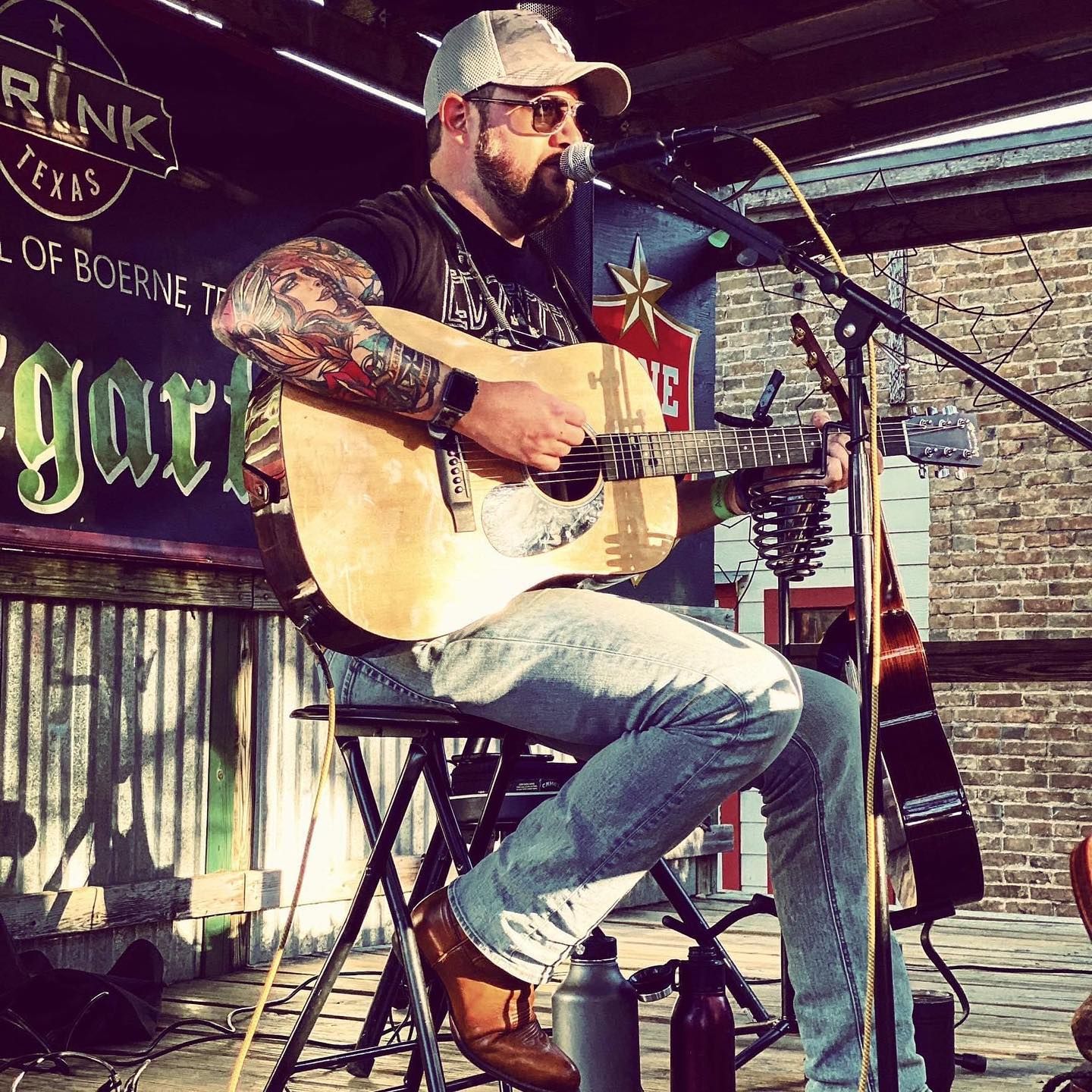 A man is playing a guitar and singing into a microphone.