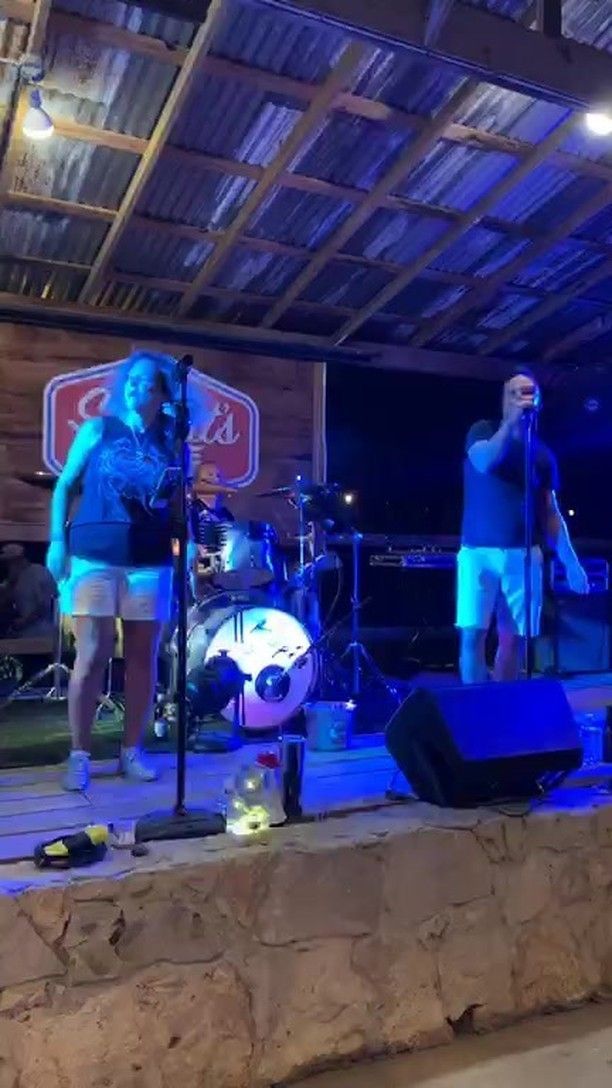 A group of people are standing on a stage in front of a microphone.