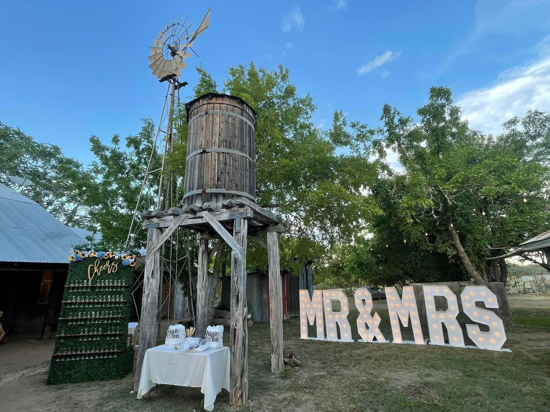 A wooden water tower with an Mr. and Mrs. sign in front of it.