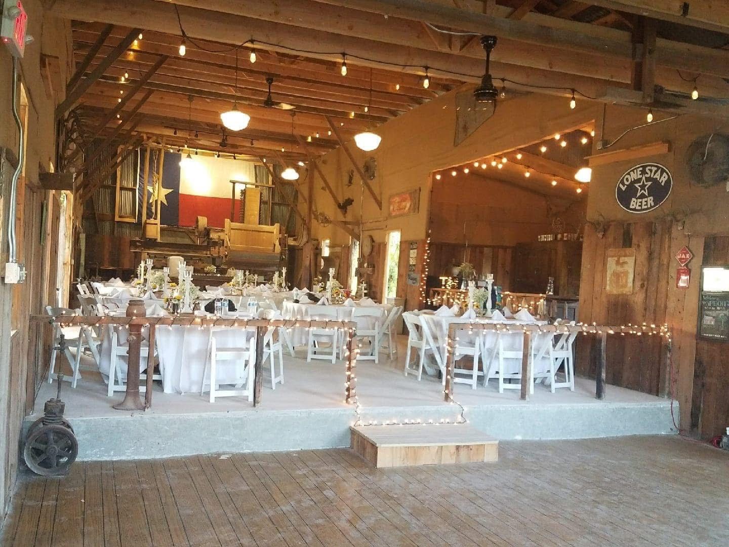 A large room with tables and chairs set up for a wedding reception.