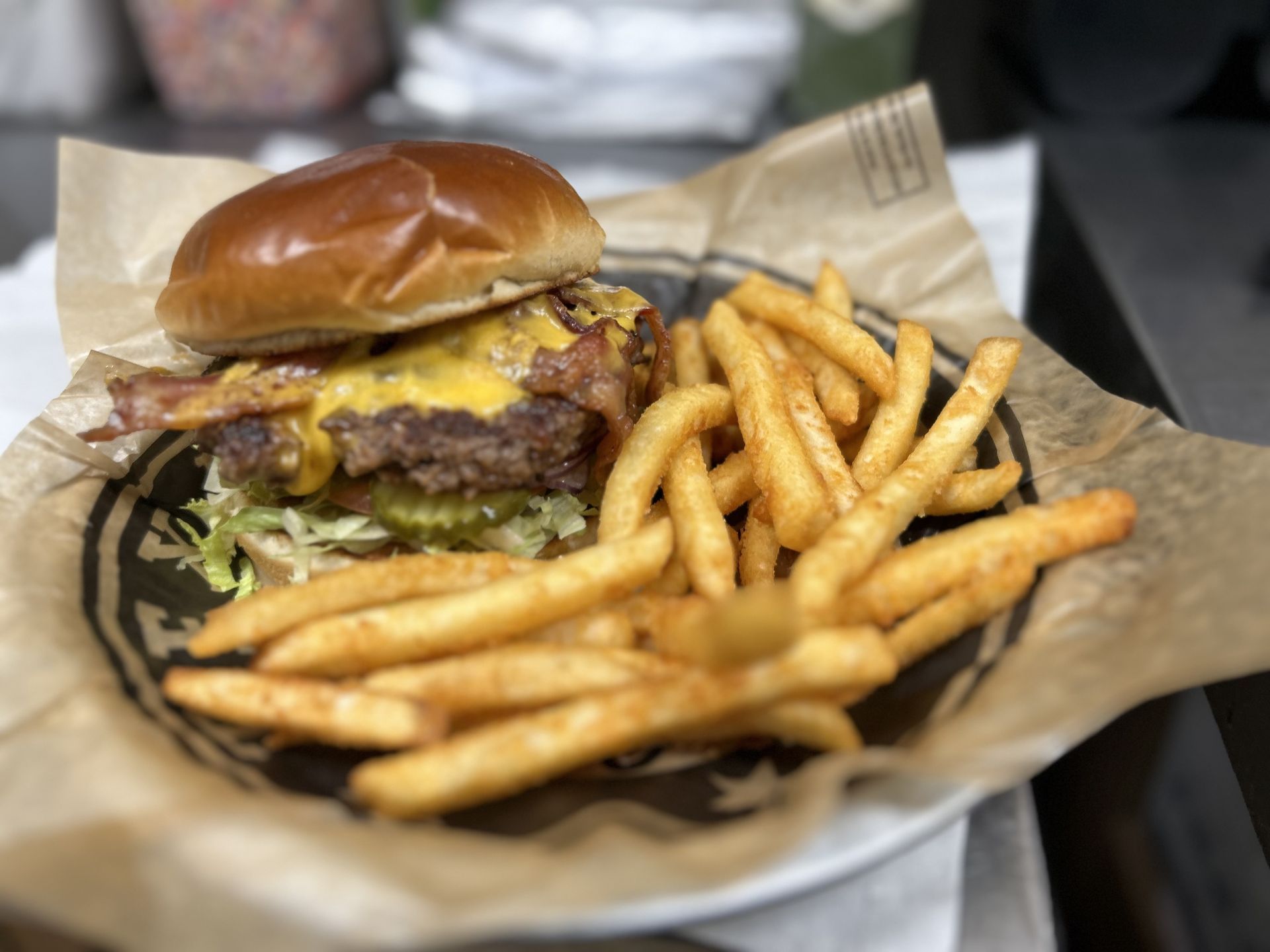 A hamburger and french fries on a plate on a table.
