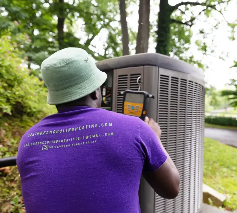 Person in purple shirt inspecting an outdoor HVAC unit in a wooded yard