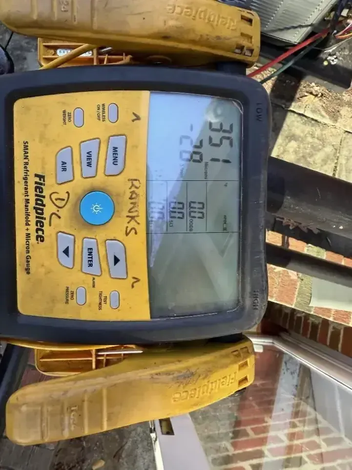 Yellow Fluke digital meter displaying 35.2°C and 92.0°F with probe leads attached
