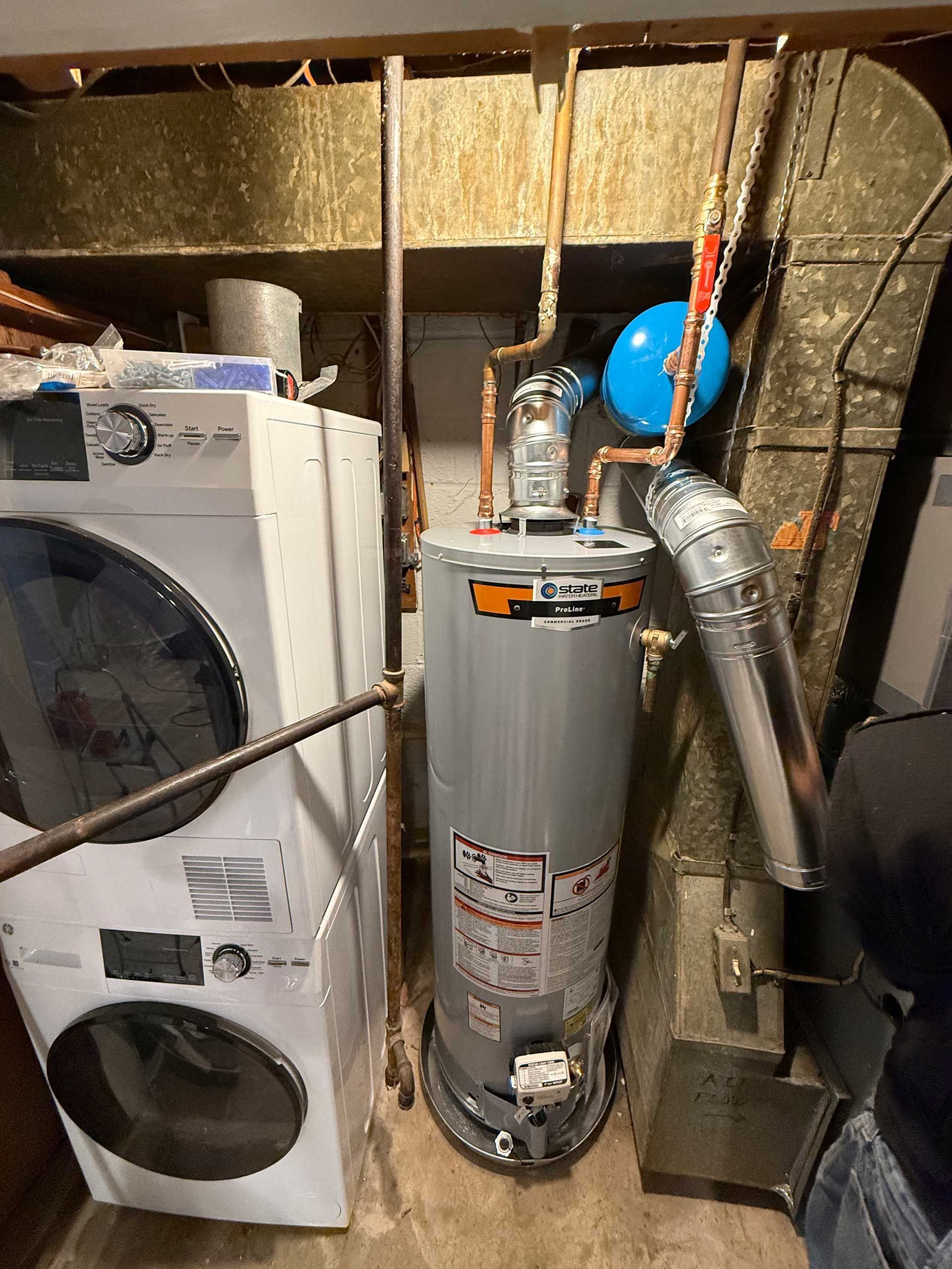 Laundry room with washer and water heater, plus exposed ductwork and pipes.