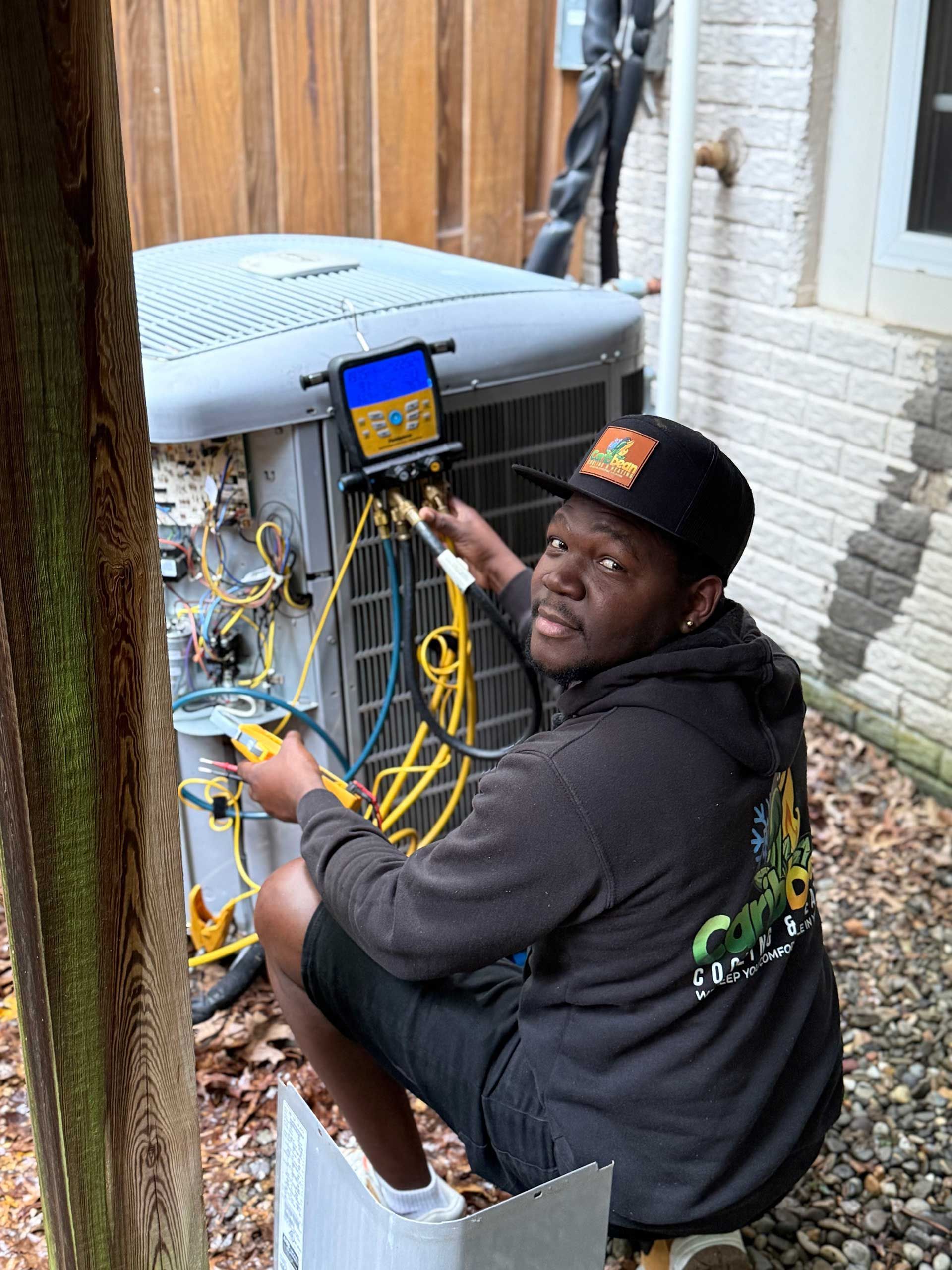 Technician working on an outdoor HVAC unit with tools and yellow cables.