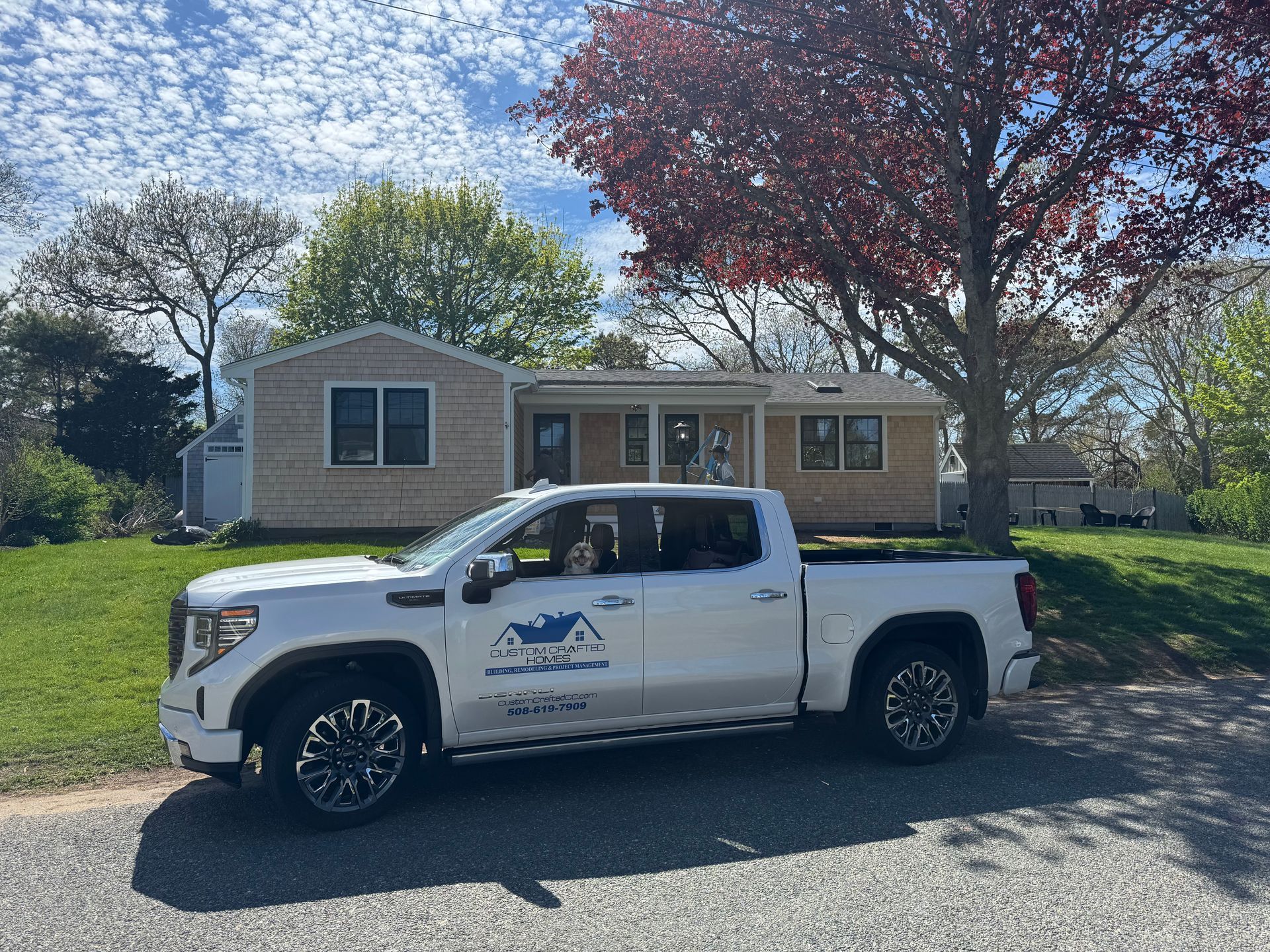 A white truck is parked in front of a house.