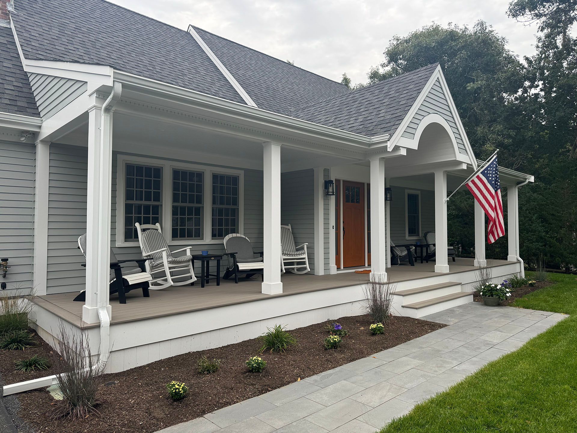 A house with a large porch and a flag on it.