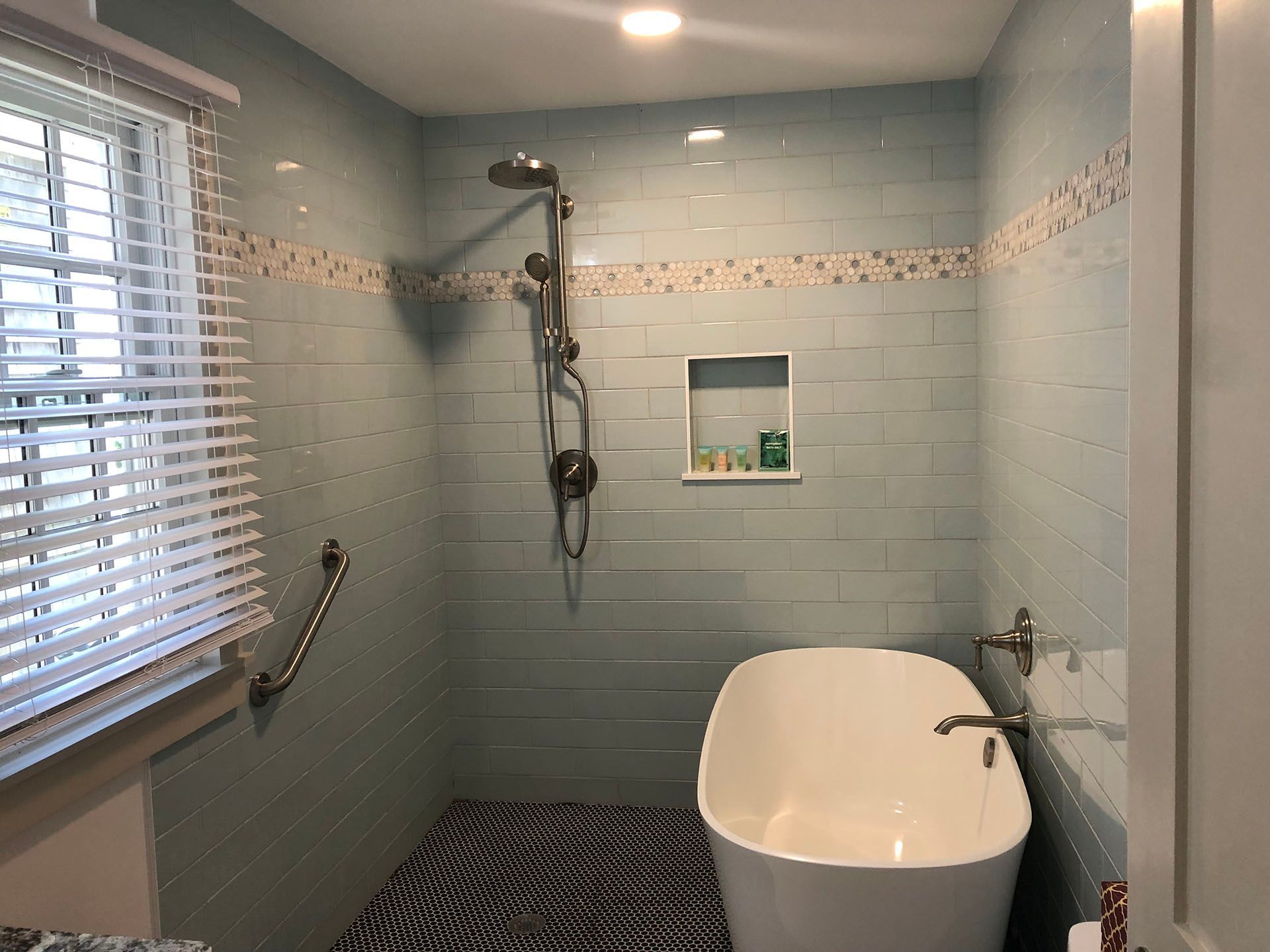 A bathroom with a tub, shower, and window.
