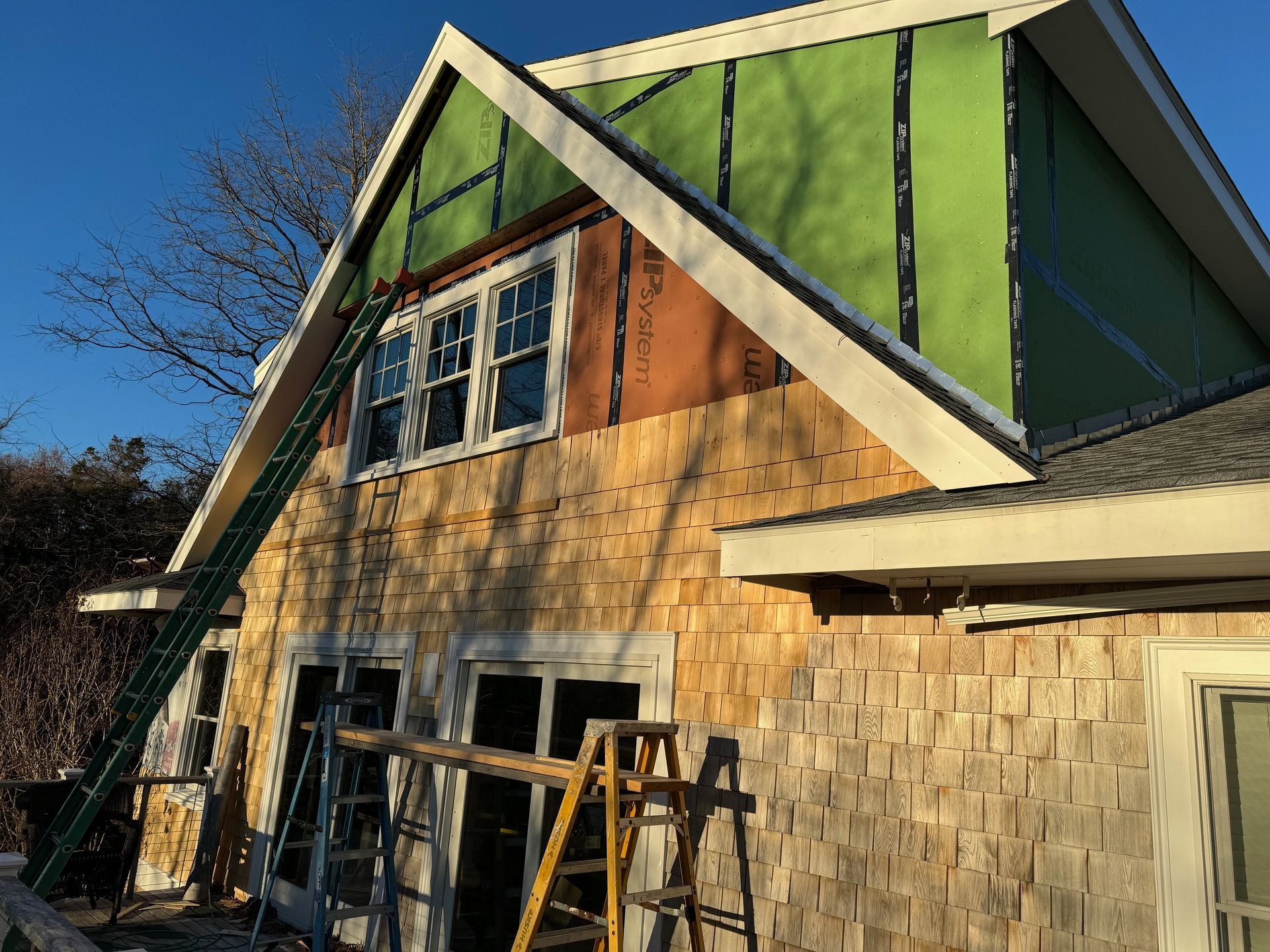 A house with a green roof is being remodeled.