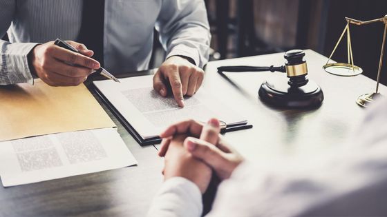 Lawyer with documents and gavel on a desk, discussing a contract.