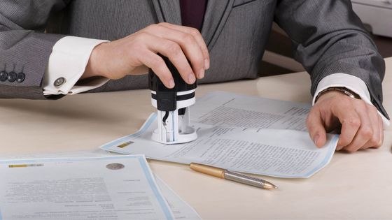 Lawyer using a stamp on paperwork at a desk
