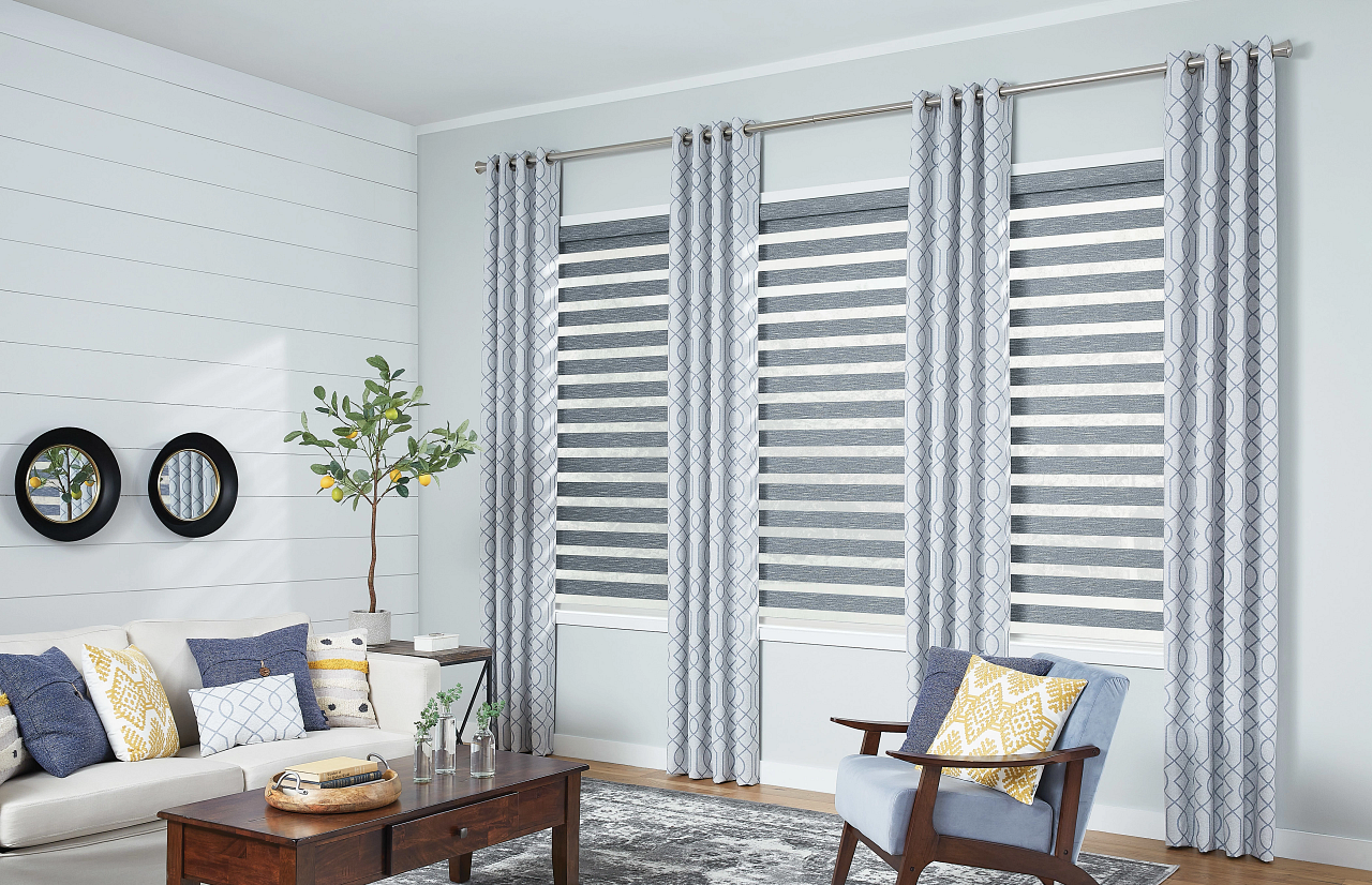 Bright living room with striped curtains, sofa, chair, coffee table, and wall decor