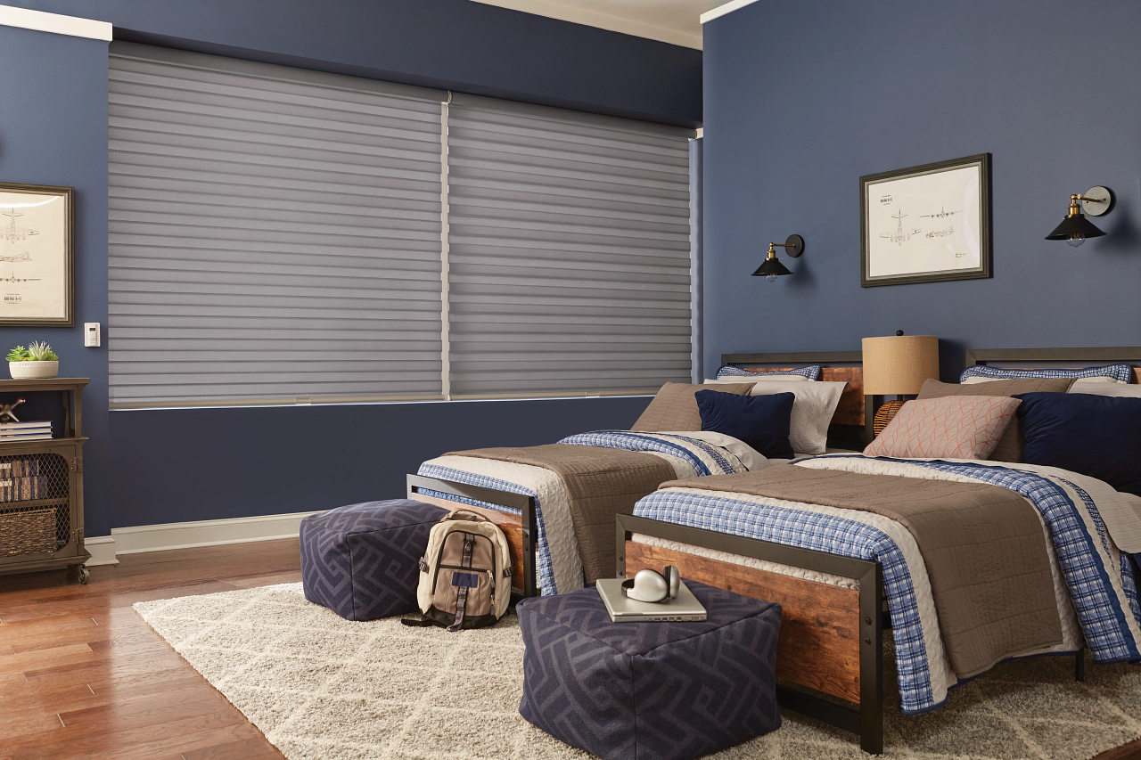 Cozy blue bedroom with a neatly made bed, window blinds, and a bench at the foot of the bed