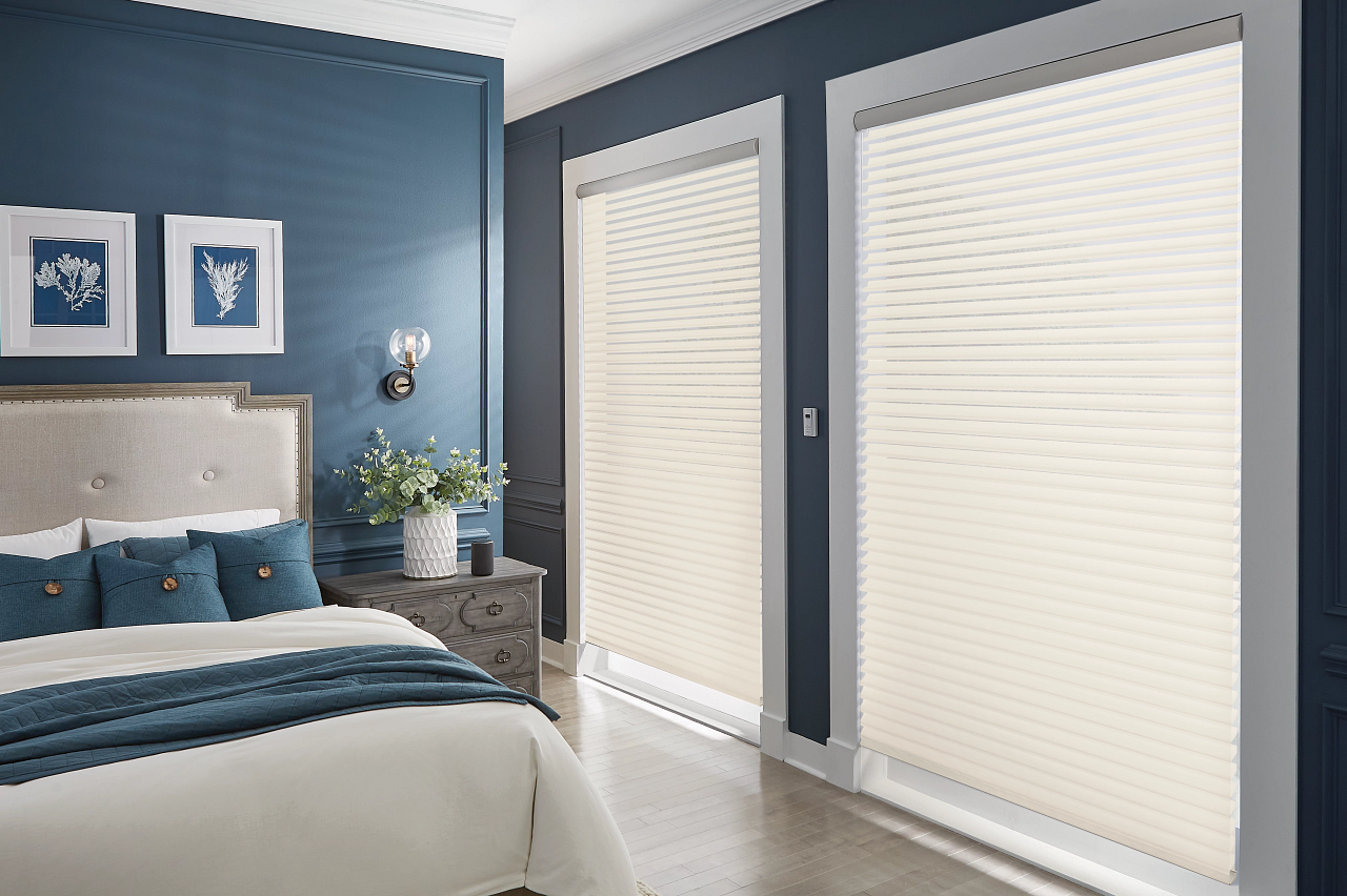 Blue bedroom with bed and dresser, featuring large white blinds on sliding glass doors
