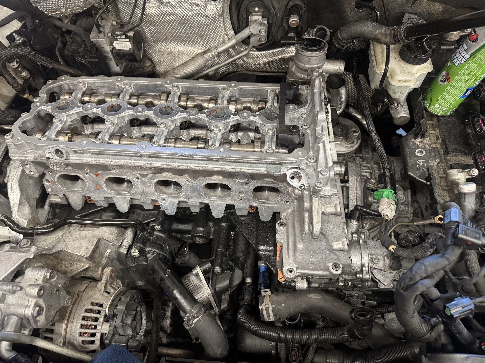 Car engine with cylinder head removed, showing exposed engine components.