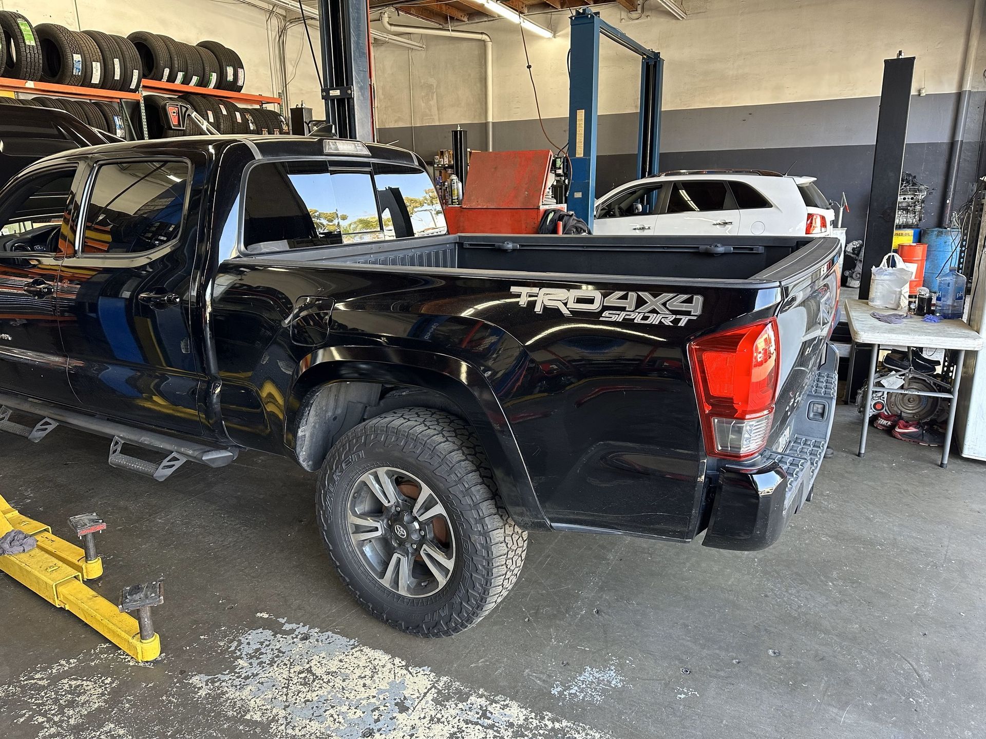 Black Toyota Tacoma truck in a garage; TRD 4x4 decal on the bed.