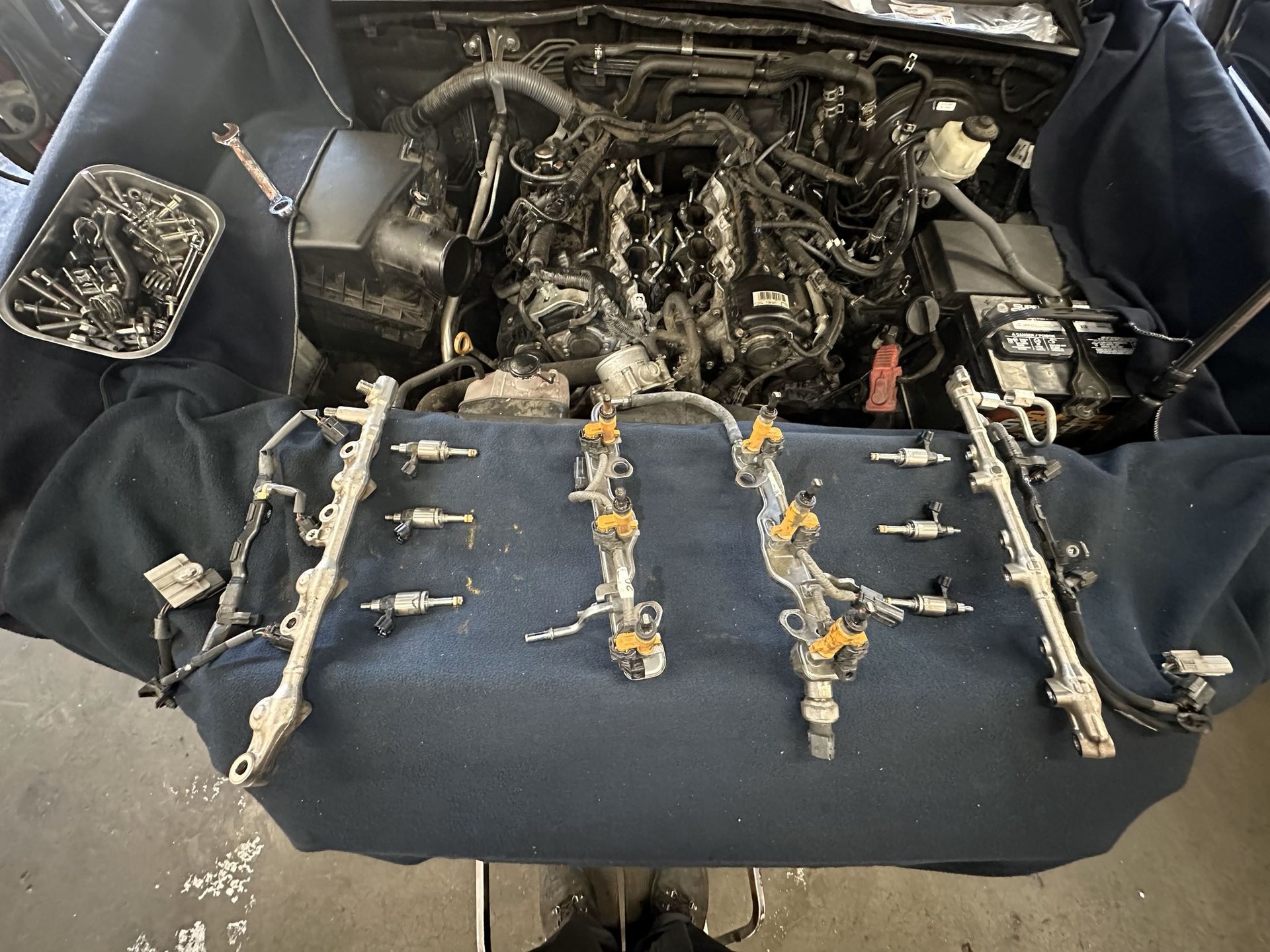 Engine bay with fuel injectors laid out for maintenance.