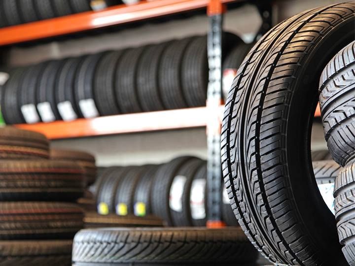 Tires stacked on shelves in a tire shop, close-up of a tread pattern.