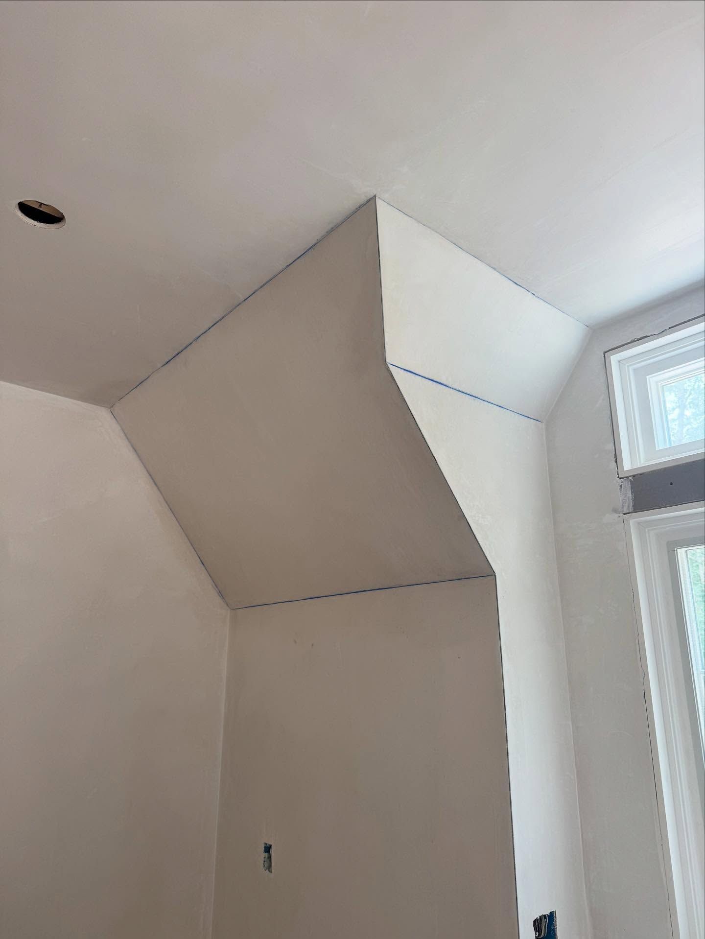 Interior corner with angled white ceiling and wall sections.