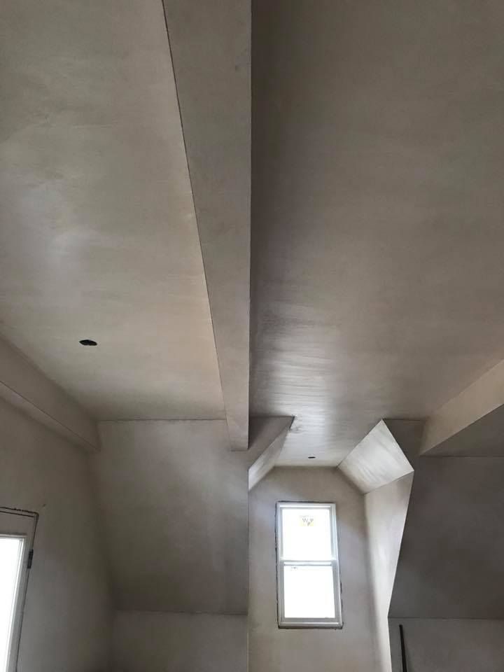 Ceiling and walls with fresh light plaster. Exposed beams, dormer window, and natural light.
