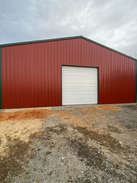 A red metal building with a white garage door.