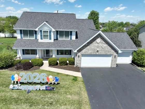 Suburban two-story house with gray siding, white trim, and a front lawn