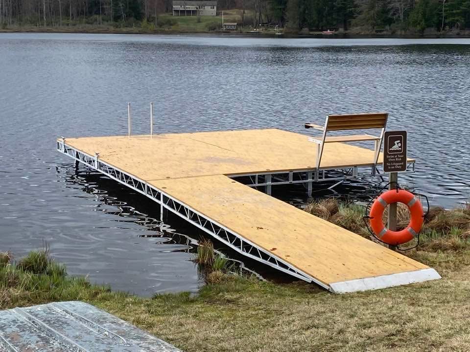 Floating wooden dock with orange life ring on a lake shore