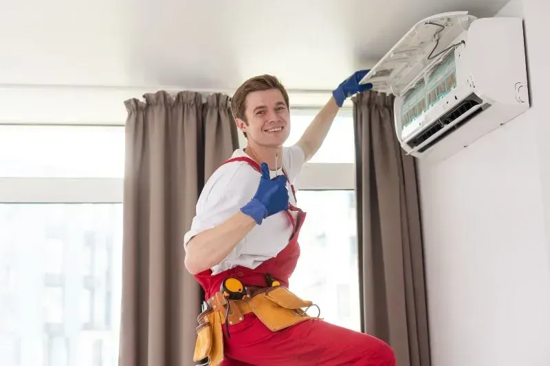 Technician Maintaining Modern Air Conditioner in Volusia & Flagler Counties