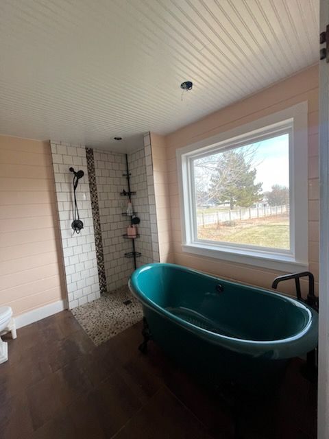 A bathroom with a green tub and a shower.