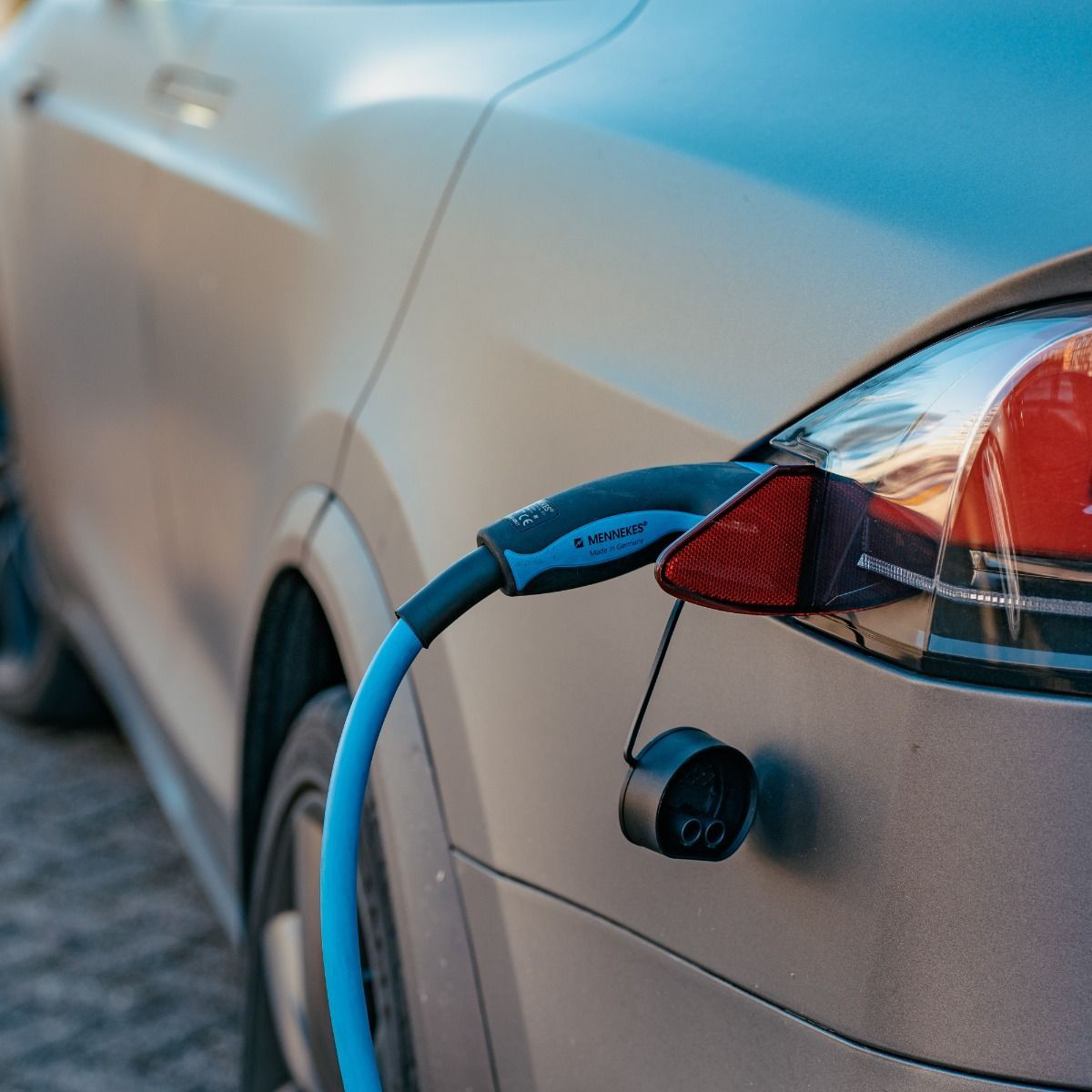 A close up of an electric car being charged