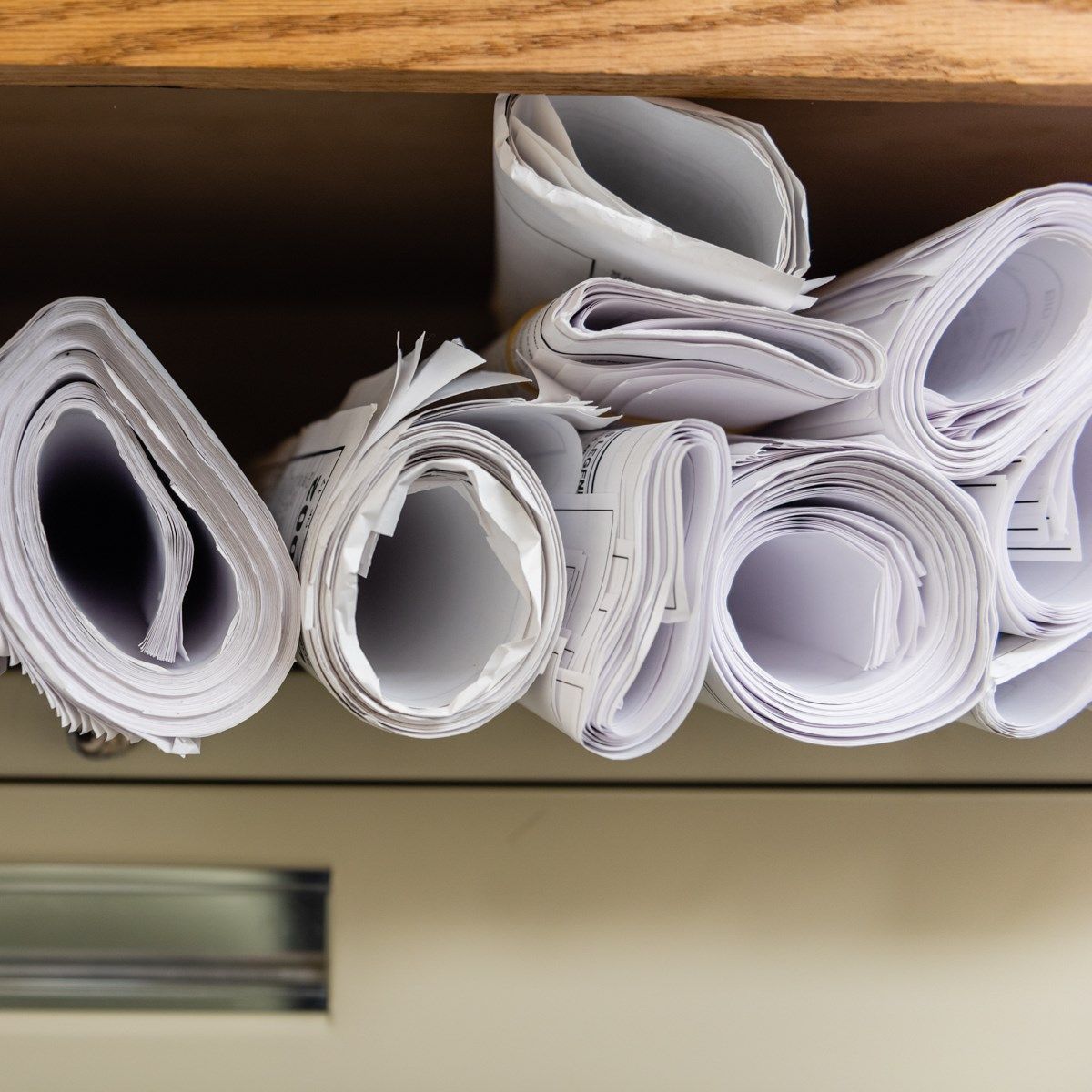 Rolls of paper are stacked on top of each other on a shelf