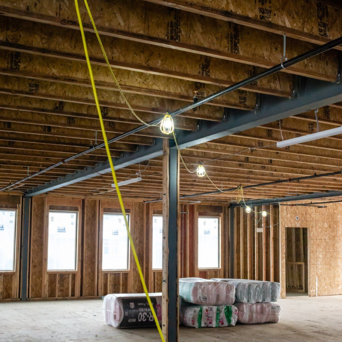 A large room with a lot of rolls of insulation on the floor