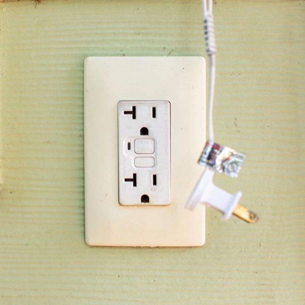 A white electrical outlet with the letter t on it