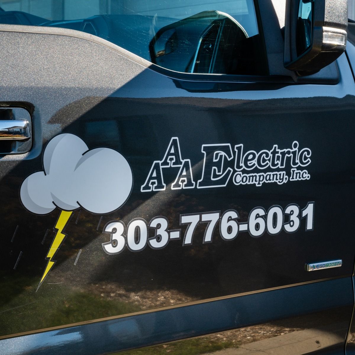 A black aa electric company truck with a lightning bolt on the side