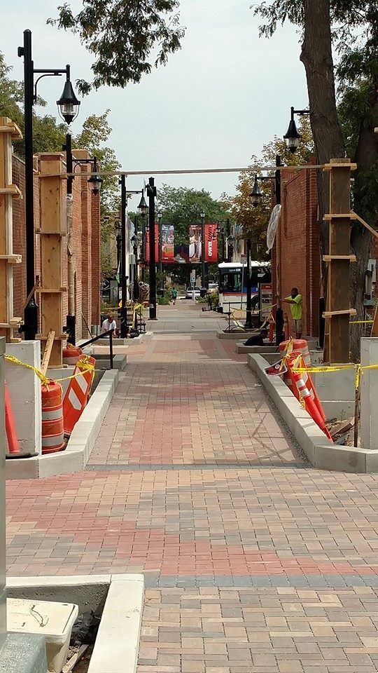 A brick walkway is being built in a city