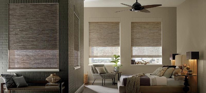 A bedroom with a couch and a bed and a ceiling fan.
