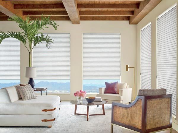 A living room with a white couch and chairs
